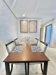 a dining room table with chairs and a wooden table at Spacious Studio with Pool & Wi-Fi in Aïn Harrouda