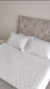 a white bed with white sheets and pillows at Estocolmo in Armenia