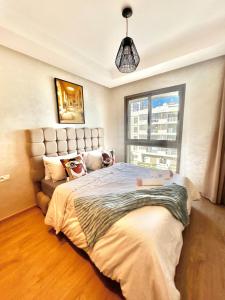 a bedroom with a large bed and a window at Spacious Studio with Pool & Wi-Fi in Aïn Harrouda +23 photos