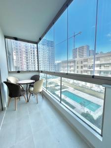 a room with a table and chairs and a large window at Spacious Studio with Pool & Wi-Fi in Aïn Harrouda