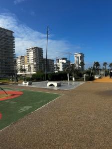 a park with benches and buildings in a city at Spacious Studio with Pool & Wi-Fi in Aïn Harrouda
