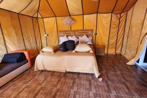 a bedroom with a bed in a tent at Nomads Trails Camp in Merzouga