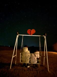 two people sitting on a swing with a heart at Nomads Trails Camp in Merzouga +4 photos