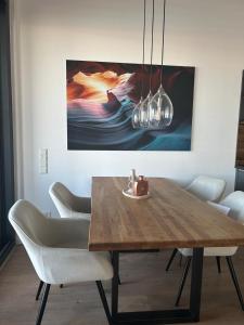 a dining room table with chairs and a painting on the wall at Traum - Apartment mit Spa im Haus in Dortmund