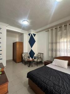 a hotel room with a bed and two chairs at Al Majd Hotel in Amman
