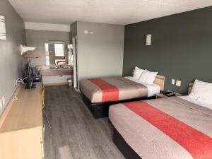 a hotel room with two beds and a sink at Red Carpet Inn And Suites in Maple Shade +3 photos