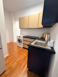 a kitchen with a sink and a washing machine at Zamkowy Hostel Gdansk Old Town in Gdańsk