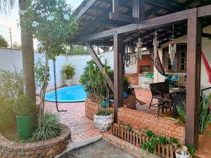 a patio with a pool and a house at Casa Conforto & Lazer Foz do Iguaçu in Foz do Iguaçu