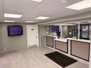 a large room with a tv on a wall at Red Carpet Inn And Suites in Maple Shade