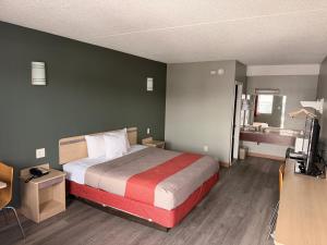 a bedroom with a bed and a desk and a television at Red Carpet Inn And Suites in Maple Shade