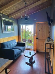 a living room with a blue couch and a table at Tu Refugio Quellon in Quellón