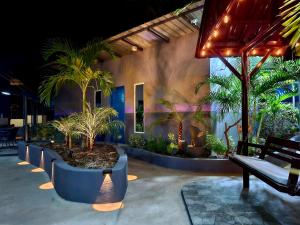 a patio with palm trees and benches in front of a building at Hidden Palms Inn Garden Deluxe in San Juan