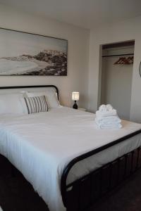 a bedroom with a large white bed with towels on it at Soleil House in Fort Saint John