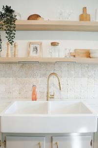a white kitchen with a sink and shelves at Soleil House in Fort Saint John +39 photos