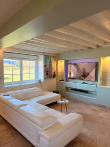 a living room with a white couch and a flat screen tv at Escale à Rosay in Theuville