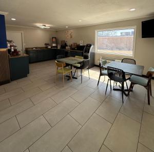 a room with tables and chairs and a kitchen at Americas Best Value Inn Ponca City in Ponca City