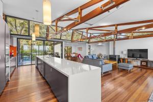 an open kitchen and living room with wood floors and ceilings at Pindimar Beach Sanctuary Absolute Beachfront in Pindimar