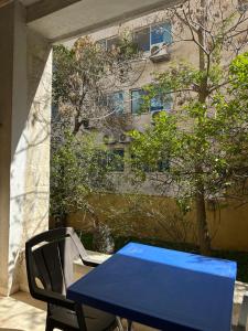 a blue table and a chair and a building at Al Majd Hotel in Amman