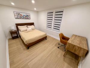 a bedroom with a bed and a table and a window at Bright & Cozy Home in Niagara Falls with Free Parking in Niagara Falls