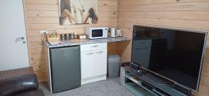 a small kitchen with a microwave and a tv at Goods Guest house in Waikino