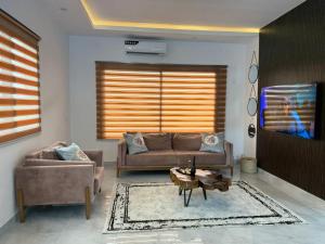a living room with a couch and a tv at Samash villa foxdale 2 bedroom in Lusaka