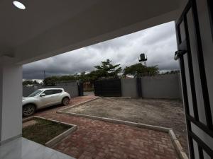 a garage with a car parked in a driveway at Samash villa foxdale 2 bedroom in Lusaka