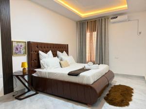 a bedroom with a large bed and a table at Samash villa foxdale 2 bedroom in Lusaka
