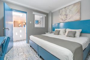 a bedroom with a large bed with a blue headboard at Hotel Adaz Mediterráneo in Santa Marta