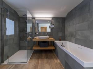 a bathroom with a tub and a sink and a shower at Mozart Lodge in Wagrain +46 photos