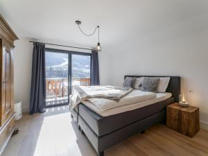 a bedroom with a bed and a large window at Mozart Lodge in Wagrain