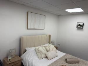 a bedroom with a bed with white sheets and pillows at The Shepherd in Hunslet