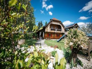 a log house with a playground in front of it at Feistritz Berg und See in Feistritz ob Bleiburg