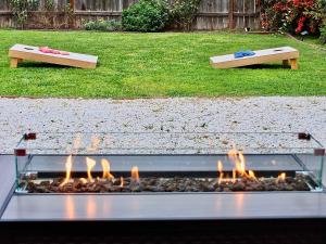 a fire pit in a yard with two benches at Charming Craftsman - Beach Close in Long Beach +44 photos