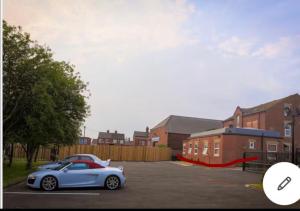 a car parked in a parking lot next to houses at The Shepherd in Hunslet