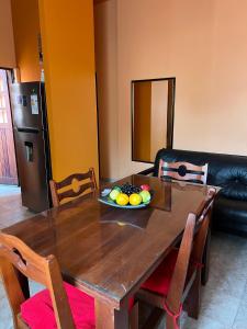 a wooden dining room table with a bowl of fruit on it at Tu departamento en Formosa in Formosa