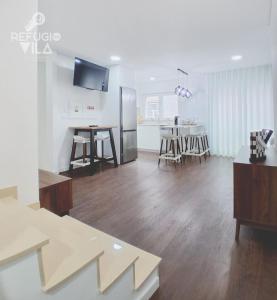 a kitchen and living room with a refrigerator and a table at Refúgio da Vila in Vila de Rei