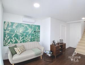 a living room with a couch and a painting on the wall at Refúgio da Vila in Vila de Rei