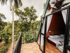 a room with a bed on the balcony of a house at Sunshine Cabana and Resort in Haldummulla