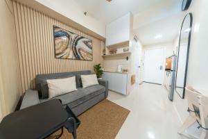 a living room with a couch and a kitchen at Modern Stays Makati Pool View Jazz Residences in Manila