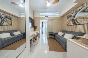 a living room with a couch and a table at Modern Stays Makati Pool View Jazz Residences in Manila