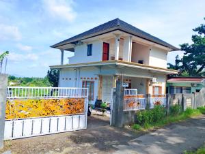 a house with a white fence in front of it at Traveling Guest House - Shared Kitchen in Kuta Lombok