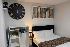 a bedroom with a clock on the wall and a bed at Birmingham Central Luxury Suites in Birmingham