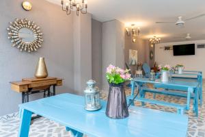 a blue table with flowers in a vase on it at Hotel Adaz Mediterráneo in Santa Marta