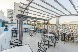 a patio with tables and chairs and a pool at Hotel Adaz Mediterráneo in Santa Marta