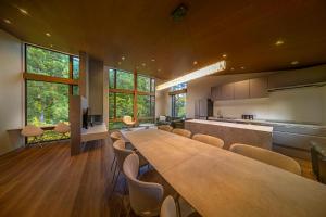 a large dining room with a long table and chairs at Chalet Infinity in Hakuba