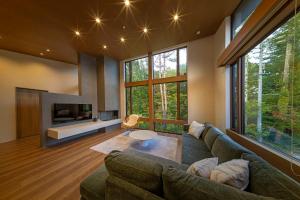a living room with a couch and a tv at Chalet Infinity in Hakuba