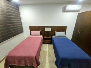 two beds in a small room with at Cancún Arbolada Huayacan in Cancún