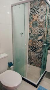a bathroom with a toilet and a glass shower at Pousada Mirante do Atalaia Oficial II in Arraial do Cabo +35 photos