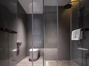 a bathroom with a toilet and a glass shower at Jiuzhaigou A HOTEL in Jiuzhaigou