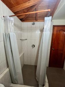 a bathroom with a shower with a shower curtain at Granja Doña Carmelita in Ibarra